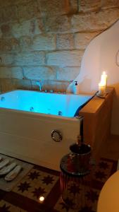 MiggianoLe Antiche Dimore di Dea的浴室配有带蜡烛和蜡烛的浴缸。