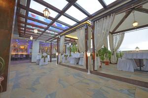 奥兰加巴德JP国际酒店的宴会厅配有白色的桌子和白色的窗帘