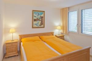 采尔马特克林内塔公寓的一间卧室配有一张带黄床单和两盏灯的床。