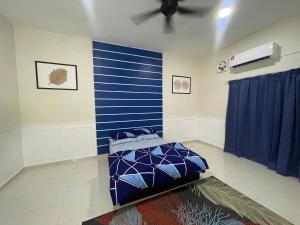 卢穆特No 61 Nazirin Homestay Tmn Indah Raya 2 Manjung Lumut的一间设有蓝色墙壁和一张床的客房