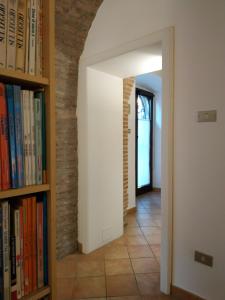 韦诺萨Bed and Breakfast In Piazza Orazio的走廊上设有书架和砖墙