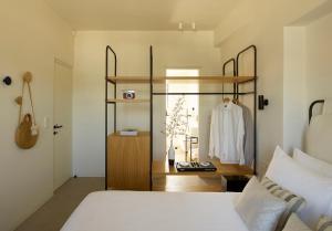 利瓦迪奥Chill & Co. Serifos的一间卧室配有一张床和一个带浴袍的架子