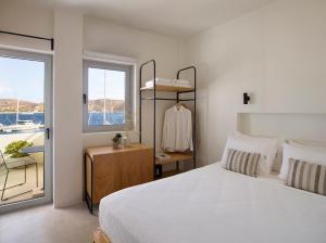 利瓦迪奥Chill & Co. Serifos的卧室配有白色的床和窗户。