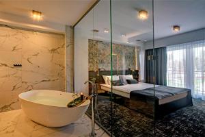 萨诺克Hotel Wiki Sanok Events & Bowling的带浴缸的浴室和1间带1张床的卧室