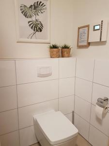 库克斯港Ferienwohnung Quartier HOHE GEEST 12的一间带卫生间的浴室和墙上的照片