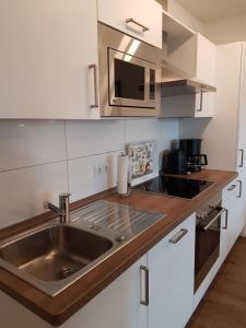 库克斯港Ferienwohnung Quartier HOHE GEEST 12的厨房配有水槽和微波炉