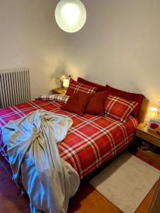 伊索拉察Cima de’ Piazzi Apartment的一间卧室配有一张带红色铺面毯子的床