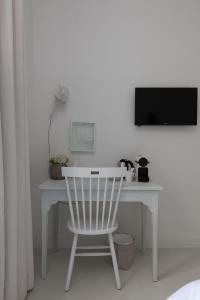 乌得勒支鹅妈妈酒店的白色的书桌、白色的椅子和电视