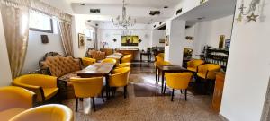 布加勒斯特5 Stars High Hostel的一间餐厅,房间内设有黄色的椅子和桌子