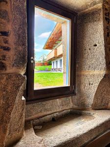 阿尔苏阿Rectoral de Boente的石墙窗户,享有房子的景色