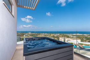 赫索尼索斯Onira Suite Dreams的海景阳台上的热水浴池