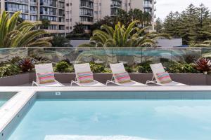 克罗纳拉Rydges Cronulla Beachside的一组椅子坐在游泳池旁