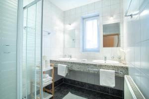 菲根Zillertal Appartements的一间带两个水槽和玻璃淋浴间的浴室