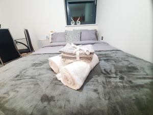 伦敦LiveStay-Modern 3 Bed Apt on 8th Floor with Amazing Views的一间卧室配有带毛巾的床