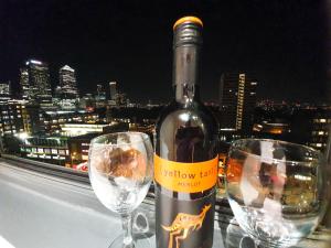 伦敦LiveStay-Modern 3 Bed Apt on 8th Floor with Amazing Views的两杯酒杯旁的一瓶葡萄酒