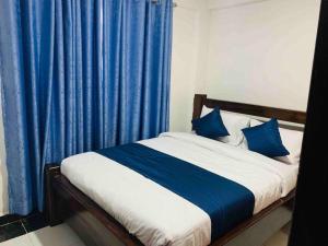 奈瓦沙EM's Place Bridge View Furnished Apartments Naivasha的一间卧室配有蓝色窗帘的床