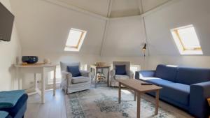 斯海弗宁恩Alta Mar Studios的客厅配有蓝色的沙发和两把椅子