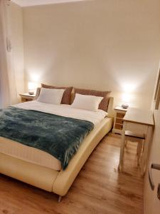 纳尔瓦约埃苏Sand Beach Apartment的卧室内的一张床位,配有两张桌子和两盏灯