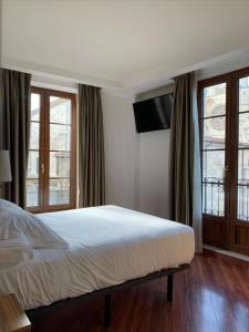 莱昂莱昂中央SpaQH酒店的卧室设有一张带窗户的白色大床