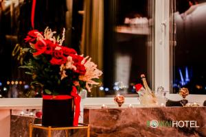地拉那Hotel Bonsai的花瓶,上面放着红色的花