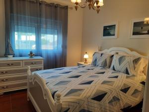 CadavalCASA DO NINHO - Entre o Campo e a Praia的一间卧室配有一张床、一个梳妆台和一扇窗户。