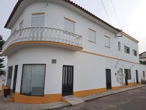 CadavalCASA DO NINHO - Entre o Campo e a Praia的白色的建筑,侧面设有阳台