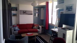 波尔多Les Bonbonieres d'Andrea Gavinies Pellegrin的客厅配有红色沙发和电视
