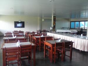 菲格雷多总统镇库卡法律酒店的一间带桌椅和电视的用餐室