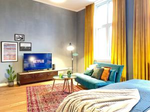 科布伦茨Klassen Stay - Exklusives Altbau Apartment - Zentral - Rheinnähe的客厅配有蓝色的沙发和电视