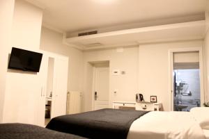 佛罗伦萨Hotel 900 Toscana的一间卧室配有一张床,墙上配有电视