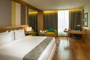 古瓦哈提古瓦哈提丽笙酒店的酒店客房设有一张大床和一张书桌。