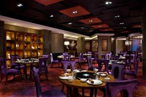 北京北京丽亭华苑酒店的一间带桌子和紫色椅子的用餐室
