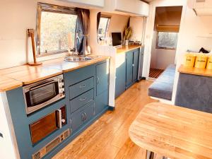 牛津Vintage 1962 airstream的厨房配有蓝色橱柜、水槽和桌子