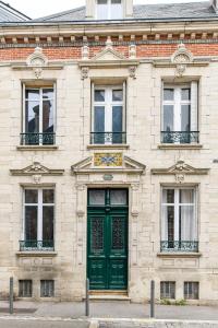 特鲁瓦La Maison de Reina的砖砌建筑的绿色门,设有窗户