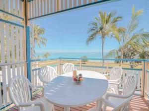 天阁露玛Villa 39 Beachfront的海滩阳台的白色桌椅