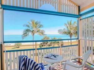 天阁露玛Villa 39 Beachfront的享有海滩和棕榈树景致的阳台