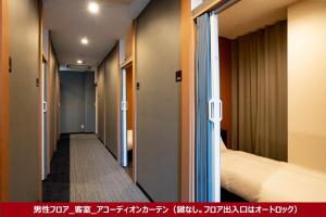 TochigiR9 Hostel Tochigi Ekimae的走廊,带一张床的酒店客房