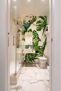 圣玛格丽塔-利古雷ORA BLU Guest house的一间带卫生间的浴室和墙上的植物