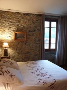 Sauveterrechambre et table d'hôtes La Grande Ourse的一间卧室设有一张床和石墙