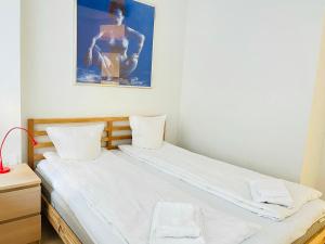 奥尔堡aday - Central cozy and bright apartment的一张大白色的床,墙上挂着一张照片