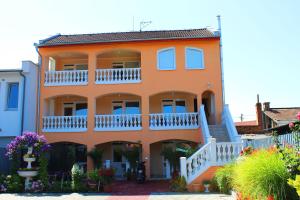 什图罗沃弗洛里达一室公寓旅馆的一座大型橙色房屋,设有白色阳台