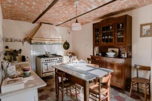 Rocca D'ArazzoLa Corte di Lu的厨房配有桌椅和炉灶。