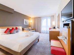 南安普敦诺富特南安普敦酒店的酒店客房设有一张大床和一张沙发。