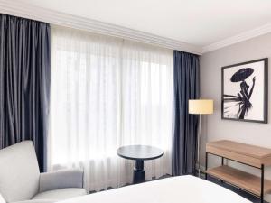 霍利索菲特伦敦盖特威克酒店的酒店客房设有床、桌子和窗户。