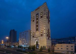 麦加Park Inn by Radisson Makkah Aziziyah的夜幕降临的城市街道上一座高楼