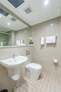 悉尼Best Western Plus Camperdown Suites的一间带水槽、卫生间和镜子的浴室