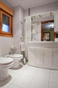 奥维多Apartamento de La Casona de Riomera的白色的浴室设有卫生间和水槽。