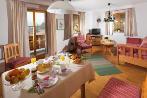 马克特谢伦贝格Ferienwohnungen Zweckl的客厅配有餐桌和食物