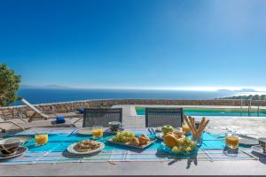 圣加利尼Tranquil sea view villa with private pool, just 2km from the beach!的一张桌子,上面有食物,享有海景