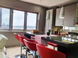 约翰内斯堡Franklin Luxury Apartment的厨房配有红色椅子和窗户台